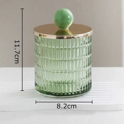 A translucent green decorbites glass tea canister with vertical ridges and a gold-toned lid storage jar