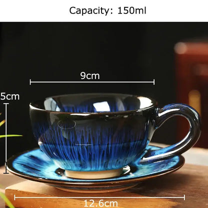 A colorful glazed porcelain tea cup and saucer set with a glossy deep blue to black gradient for dining room decor