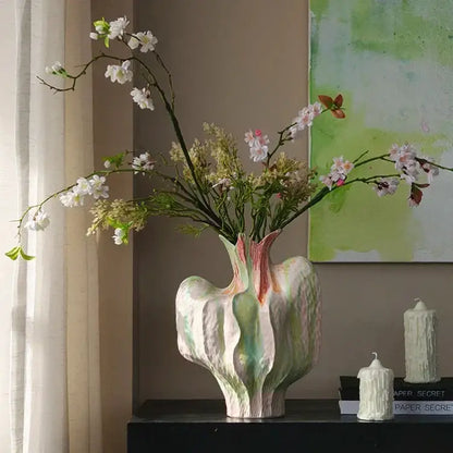 A colorful irregular ceramic petal vase with textured abstract design in soft white green and pink for living room decor