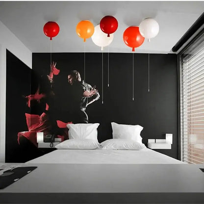 Red orange and white decorbites kids balloon pendant light floating above a bed in a modern hotel room bedroom lamp