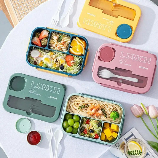 Colorful plastic lunch box set with compartmentalized sections and built-in utensils for kitchen bento use