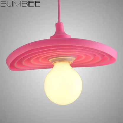 Pink bumbee pendant light with concentric circular ridges and warm glow is a decorbites colorful silicone pendant for living room decor