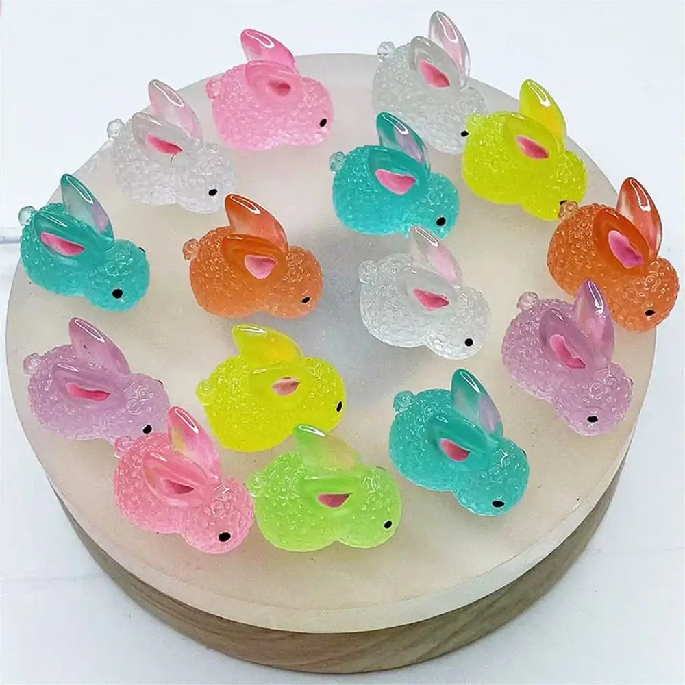 A collection of colorful translucent resin micro rabbit figurines with textured surfaces and pink inner ears for decor