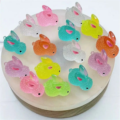 A collection of colorful translucent resin micro rabbit figurines with textured surfaces and pink inner ears for decor
