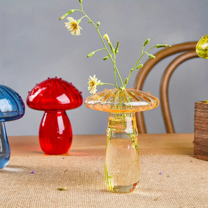 Transparent amber glass mushroom-shaped vase with textured cap holding delicate yellow flowers for living room decor