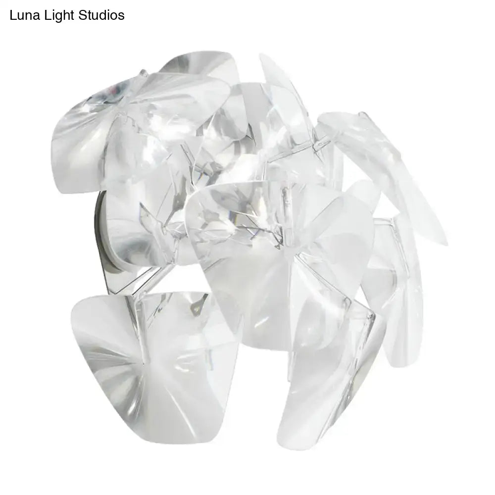 Clear faceted acrylic petals form a transparent glass shade on a contemporary acrylic single sconce light fixture