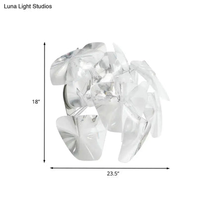 Contemporary acrylic single head sconce light fixture featuring a clear translucent acrylic leaf-shaped pendant for dining room use