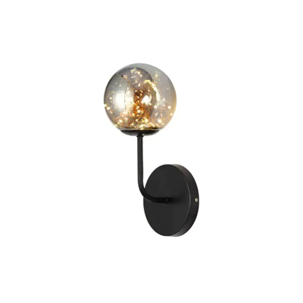 Contemporary black metal direct wired electric bedroom wall sconce with amber glass globe and golden filament light type