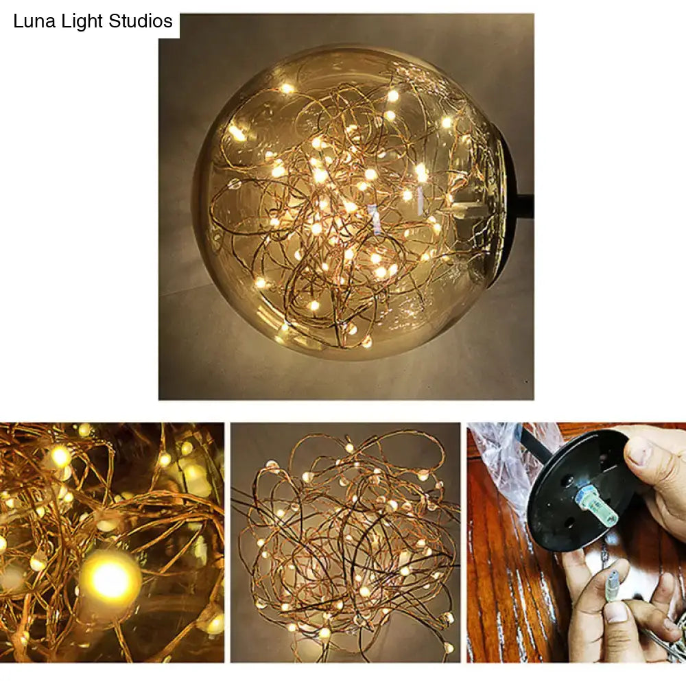 Contemporary amber glass direct wired electric bedroom wall sconce with warm-toned led string lights coiled inside a clear globe