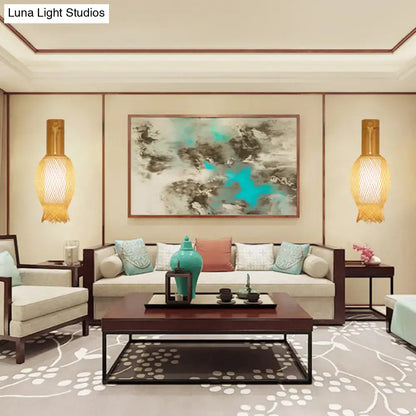 Teal ceramic vase with bulbous body on dark wooden tray beside contemporary bamboo golden wall light fixture for bedroom