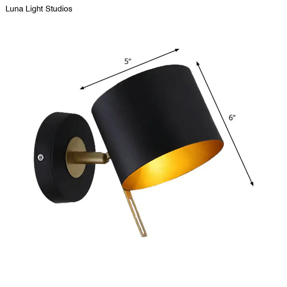 Contemporary black and gold metal drum wall sconce with brass accents for bedroom lighting