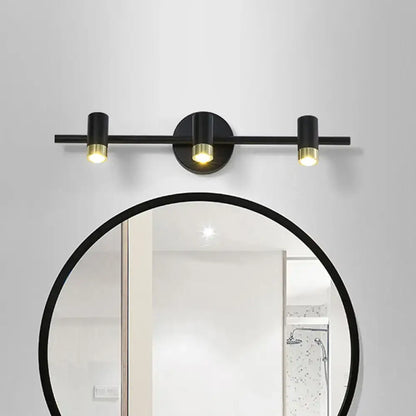Contemporary black and brass three-light vanity light wall sconce with sleek cylindrical bulbs and adjustable color temperature