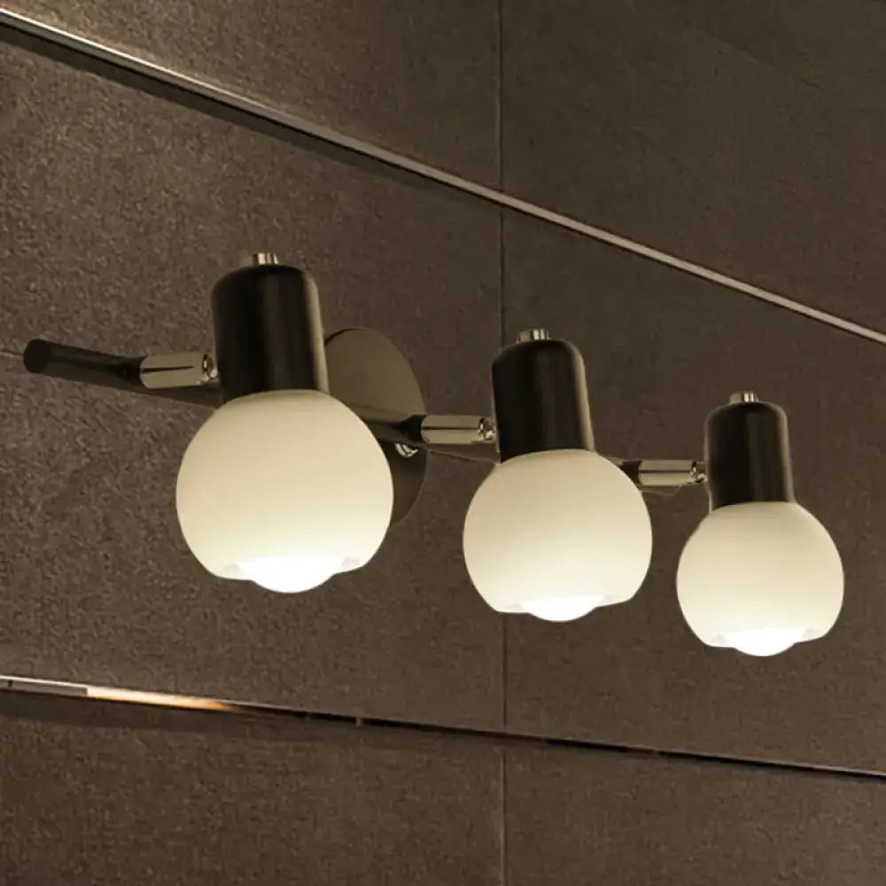 Modern three-light vanity fixture with sleek black shades and milk glass globes on polished chrome arm for living room lighting