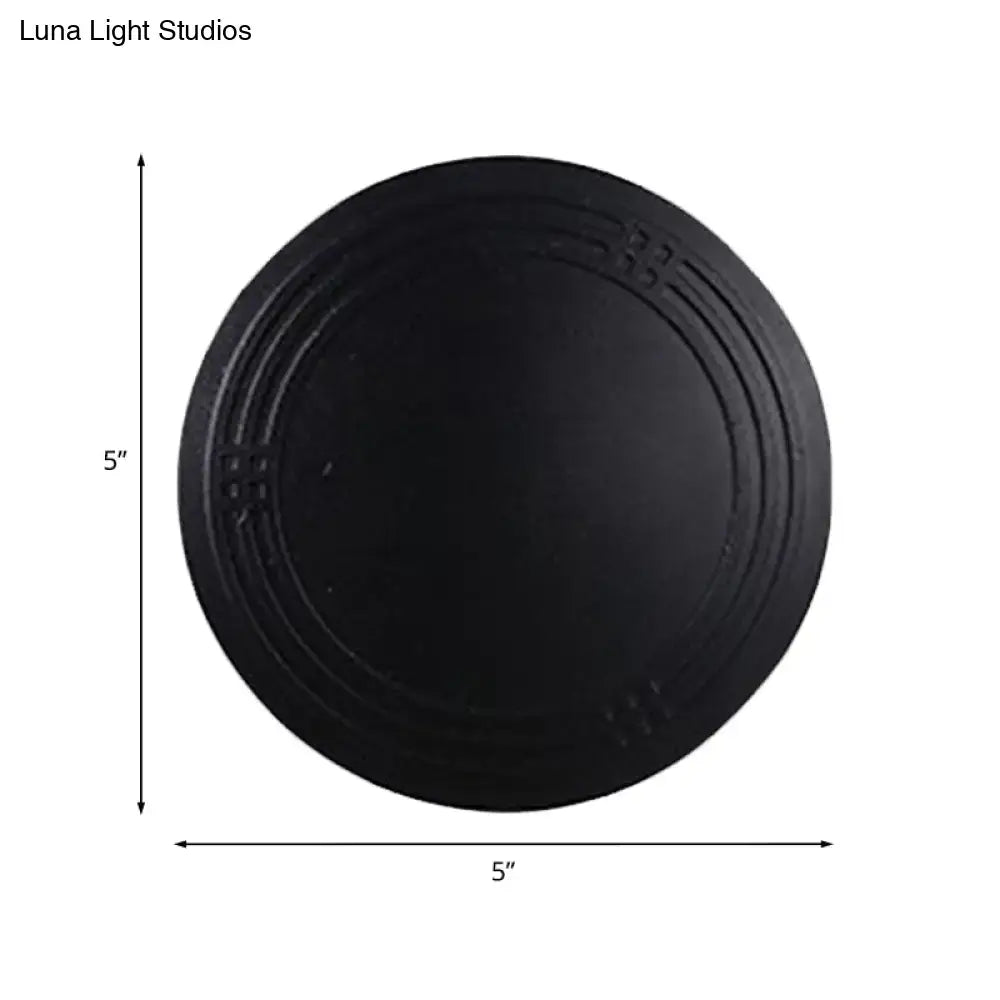 Contemporary black flower wall sconce light featuring a decorative cast iron circular wall lamp with embossed rings