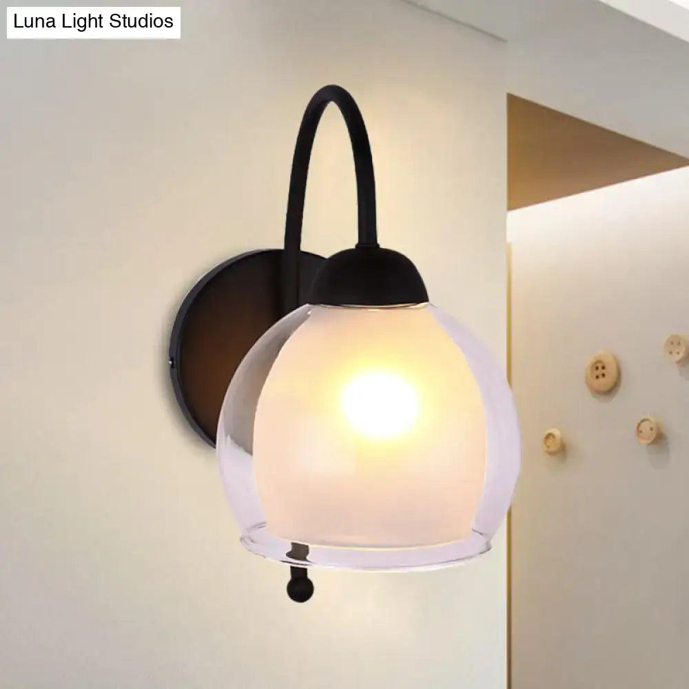 Contemporary black metal wall sconce with a frosted glass globe shade ideal for bedroom lighting