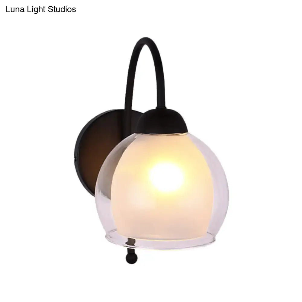 Contemporary black metal wall sconce with frosted glass globe softly diffusing warm light for bedroom use