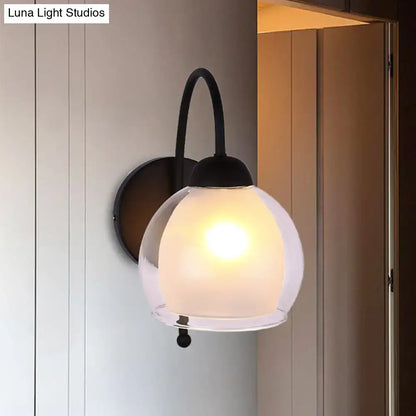 Contemporary black metal wall sconce with a frosted glass globe shade for bedroom lighting