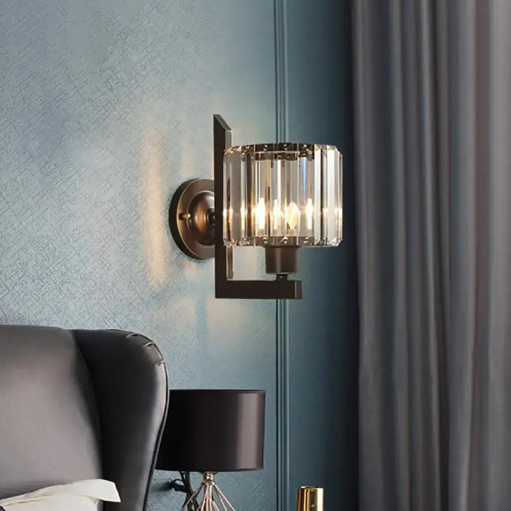 Contemporary black and gold crystal drum wall lamp with brass finish and cylindrical faceted crystal shade for bedroom lighting