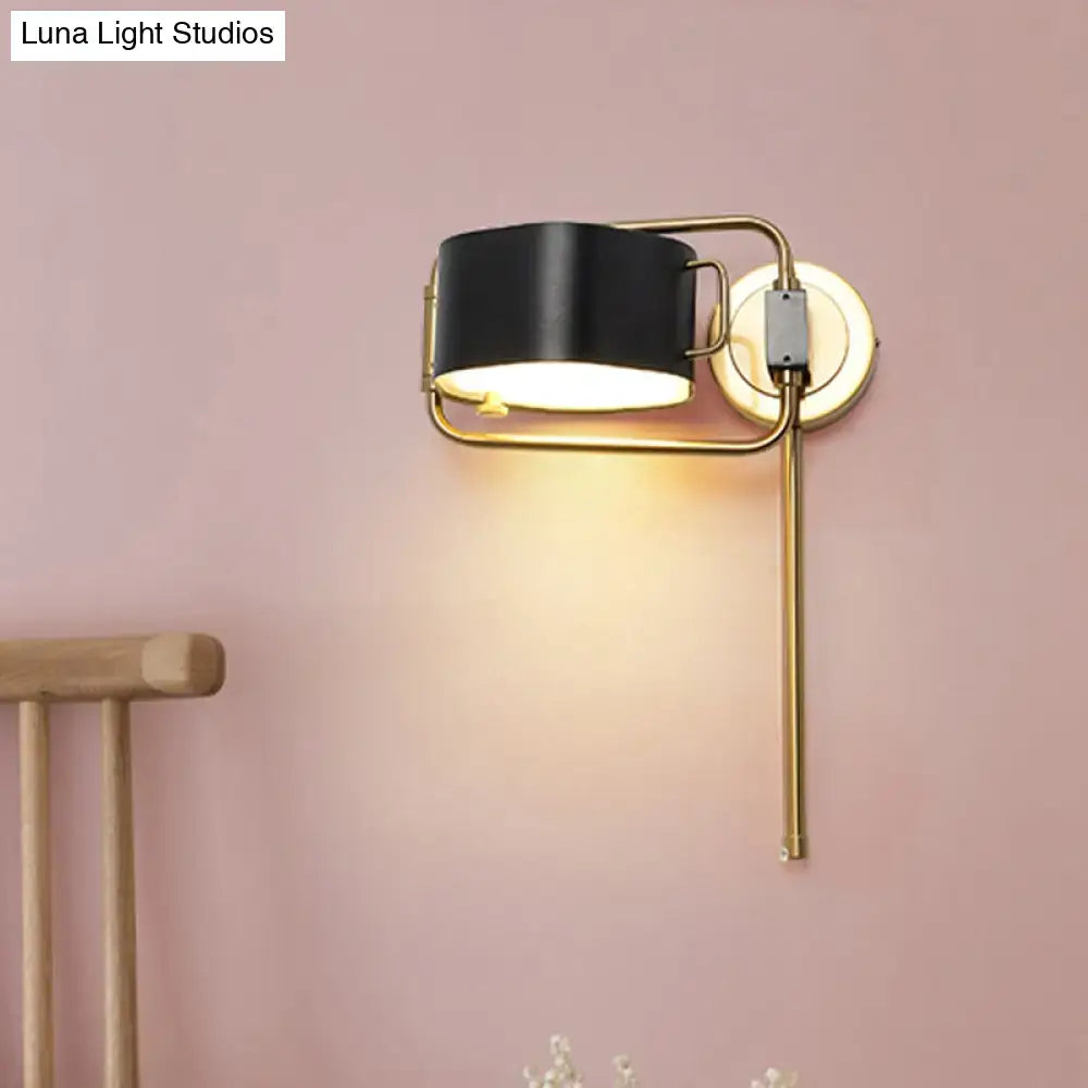 Contemporary black and gold drum wall sconce with cylindrical shade and adjustable arm for bedroom wall light LED illumination