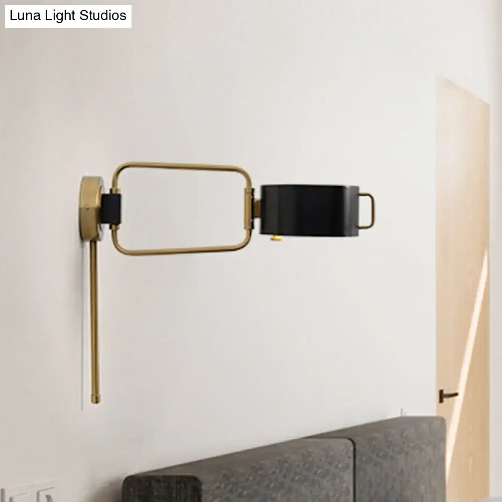 Contemporary black and gold drum wall sconce with brass frame and adjustable black shade for bedroom wall light
