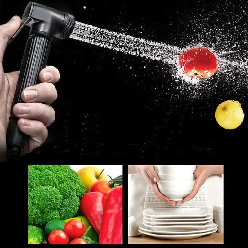 Contemporary black kitchen faucet with single handle pull out spray spraying water on tomato against dark background