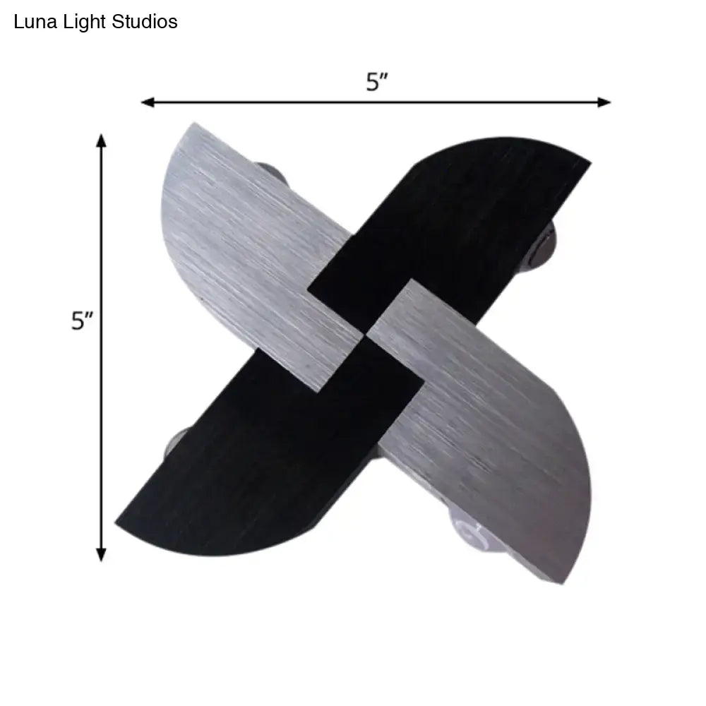 Contemporary black and silver metallic cross-shaped wall sconce with brushed finish for living room lighting