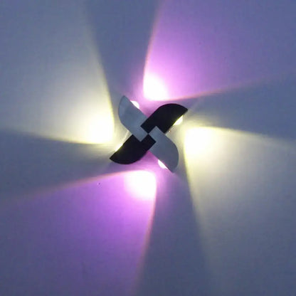 Contemporary black and silver windmill rgb wall sconce with black and white pinwheel design emitting warm yellow and purple light