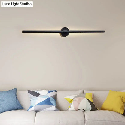 Contemporary black minimalist wall light with sleek cylindrical design and warm natural light for bedroom use