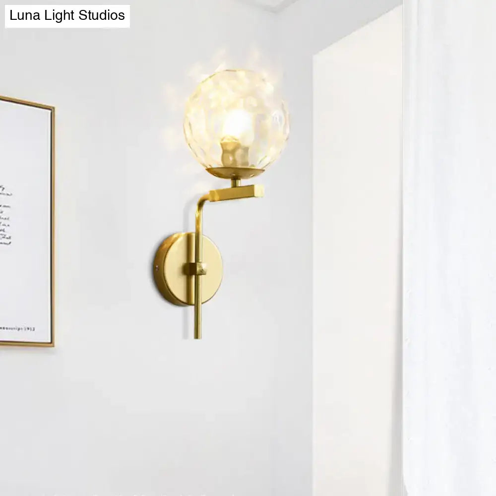 Contemporary gold-toned wall mount lighting with a textured translucent glass globe for bedroom use