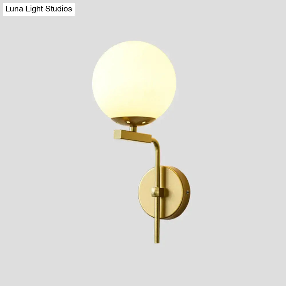 Contemporary gold-toned wall mount lighting with frosted glass globe shade ideal for bedroom wall mount lighting