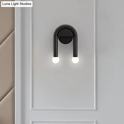 Contemporary black u-shaped light fixture bedroom wall sconce with two glowing spherical bulbs and sleek design