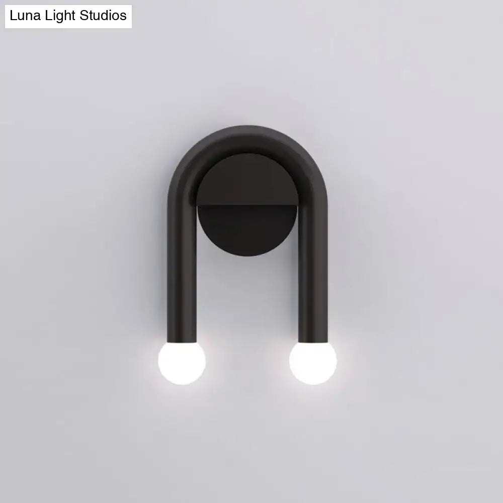 Contemporary black u-shaped light fixture wall sconce with two glowing spherical bulbs for bedroom use