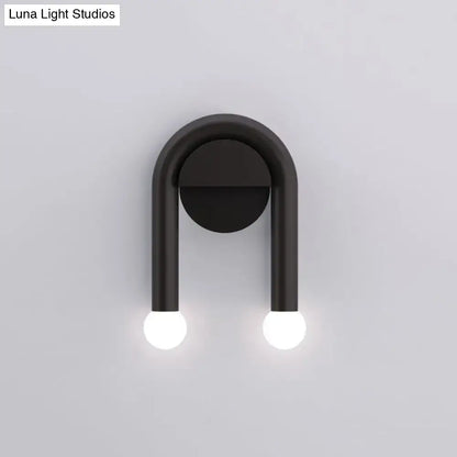 Contemporary black u-shaped light fixture wall sconce with two glowing spherical bulbs for bedroom use