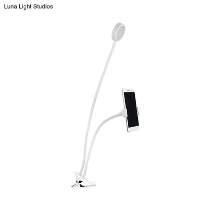 Contemporary black and white flexible led desk lamp with white gooseneck, circular light head, and phone clamp for adjustable illumination