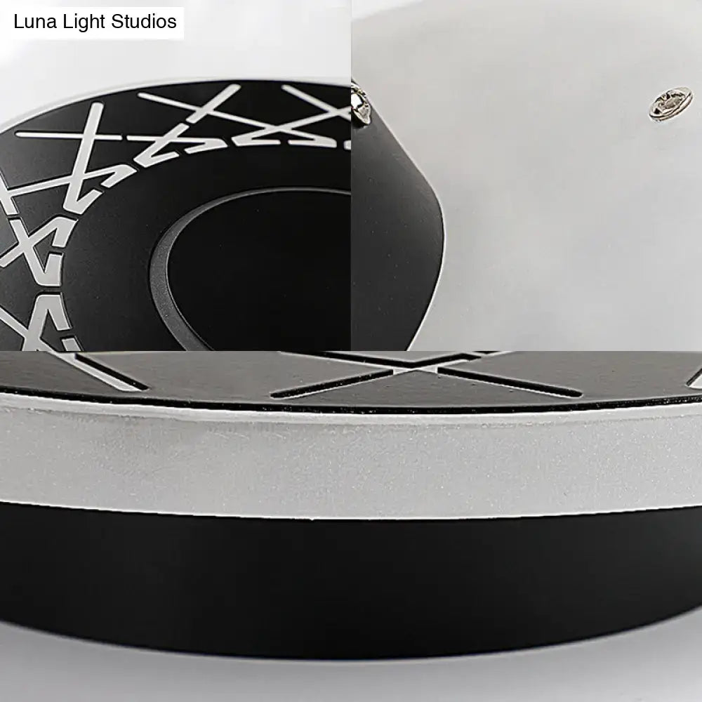 Contemporary black and white geometric wall lamp with circular x-pattern design for living room decor