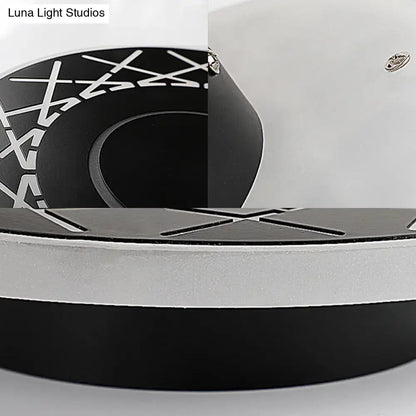 Contemporary black and white geometric wall lamp with circular x-pattern design for living room decor