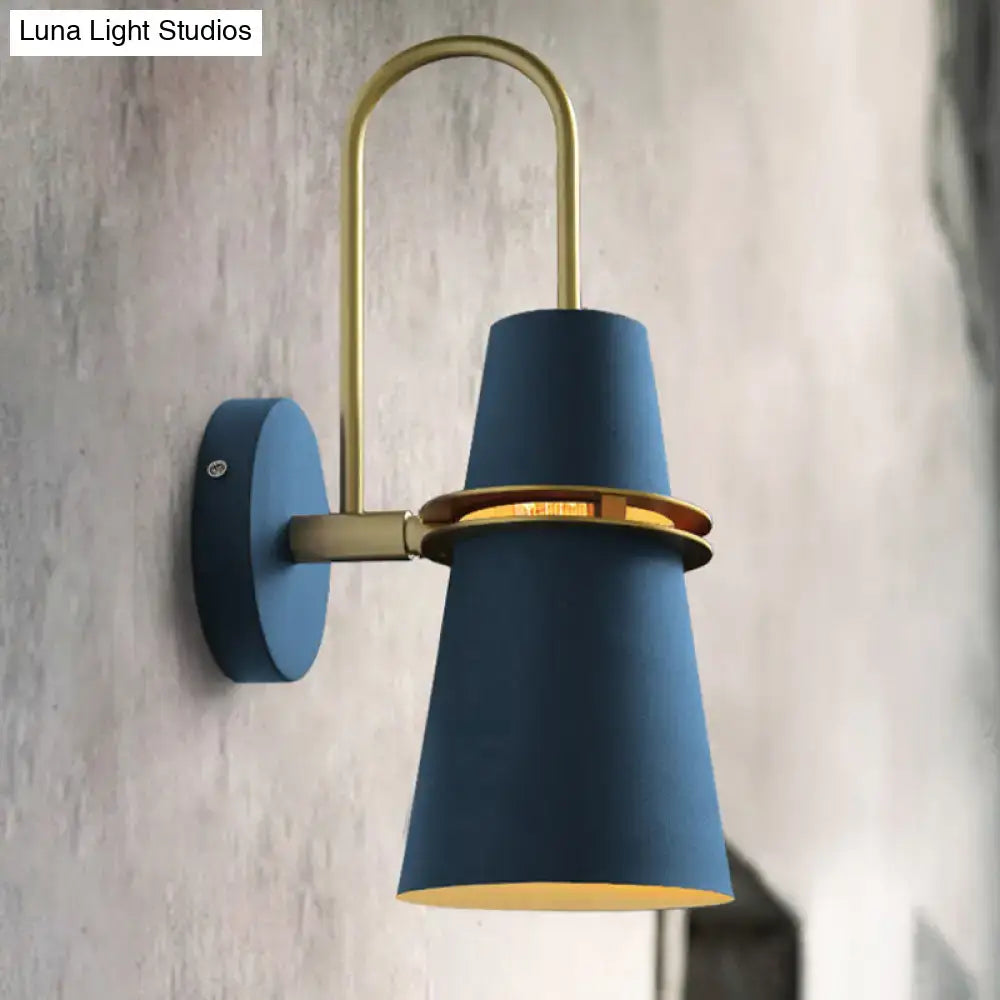 Contemporary blue and gold flared wall sconce light with brass accents and curved arm for bedroom lighting