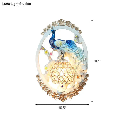 Contemporary wall sconce with blue and green peacock perched on crystal ball with gold accents for living room living space