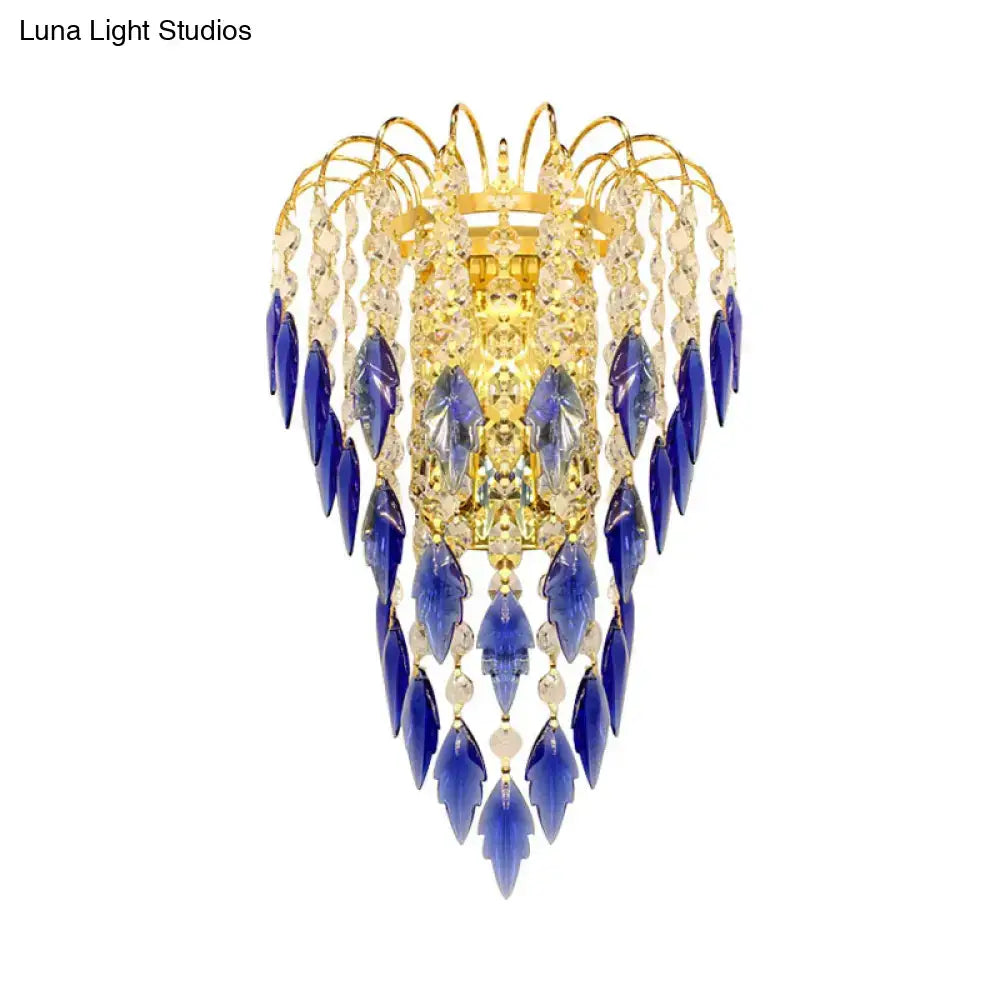 Contemporary brass wall lamp with golden chandelier design and cascading blue and clear crystal droplets for extra light