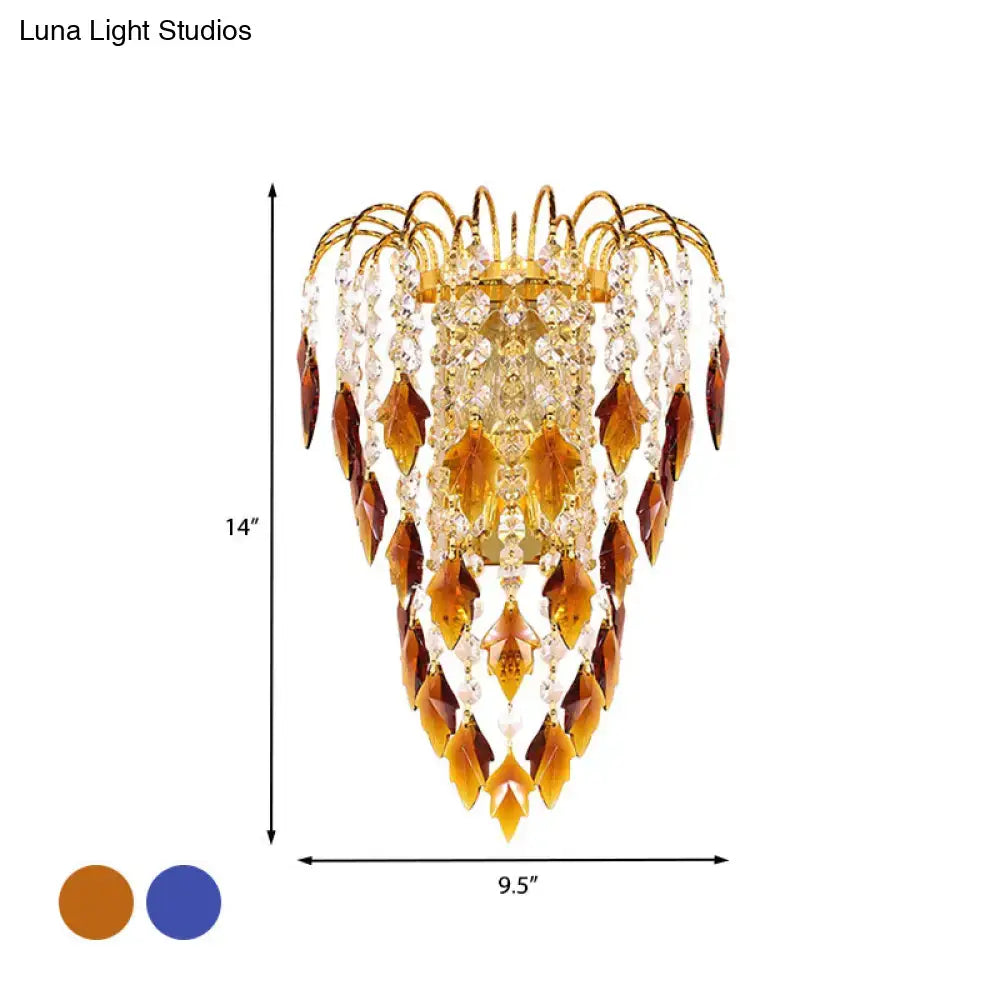 Contemporary brass wall lamp with golden-toned chandelier featuring cascading amber and clear crystal leaves for extra light