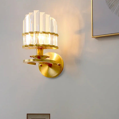 Contemporary brass wall lamp with gold-toned circular plate and clear crystal vertical prisms for e12 e14 bulbs