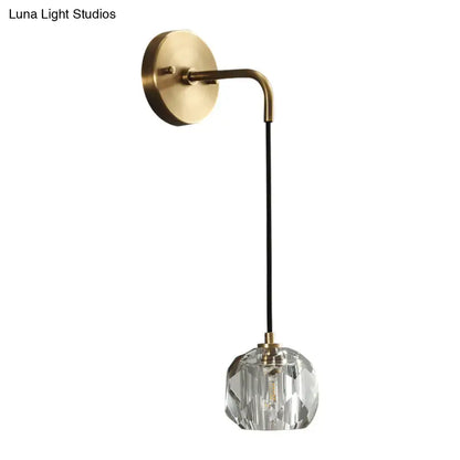 A contemporary brass wall light with a curved arm and faceted crystal shades for bedroom use