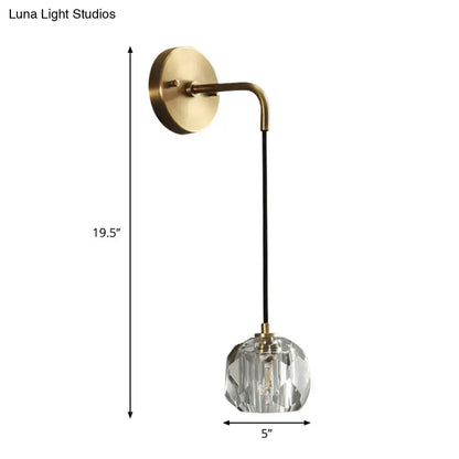 A contemporary brass wall light with a curved arm black cord and faceted crystal shades globe light fixture