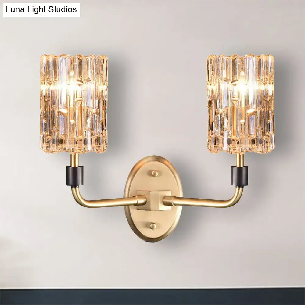 Contemporary brass bedside wall sconce with gold tone and two clear crystal shades for bedroom lighting