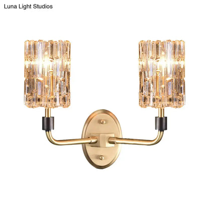 Contemporary brass bedside wall sconce with gold tone and two clear crystal shades for bedroom lighting