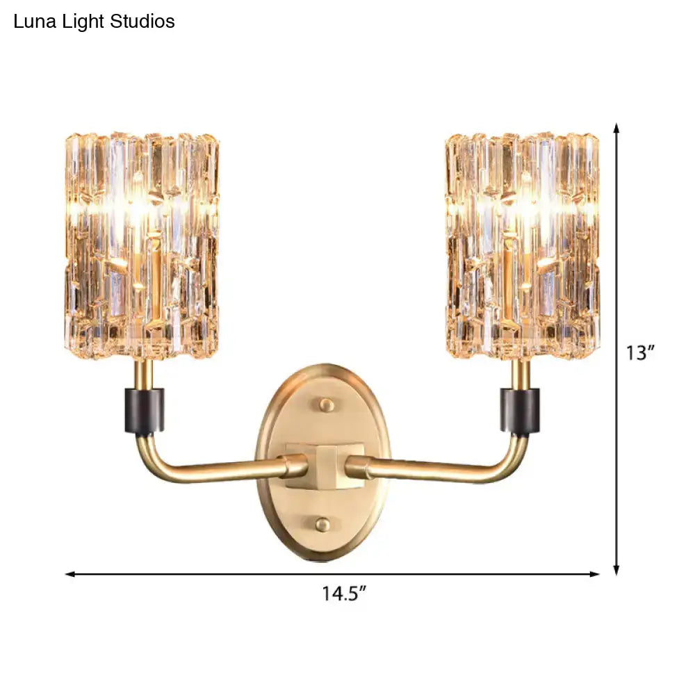 Contemporary brass bedside wall sconce with gold-toned finish and two clear crystal shade vertical glass shades