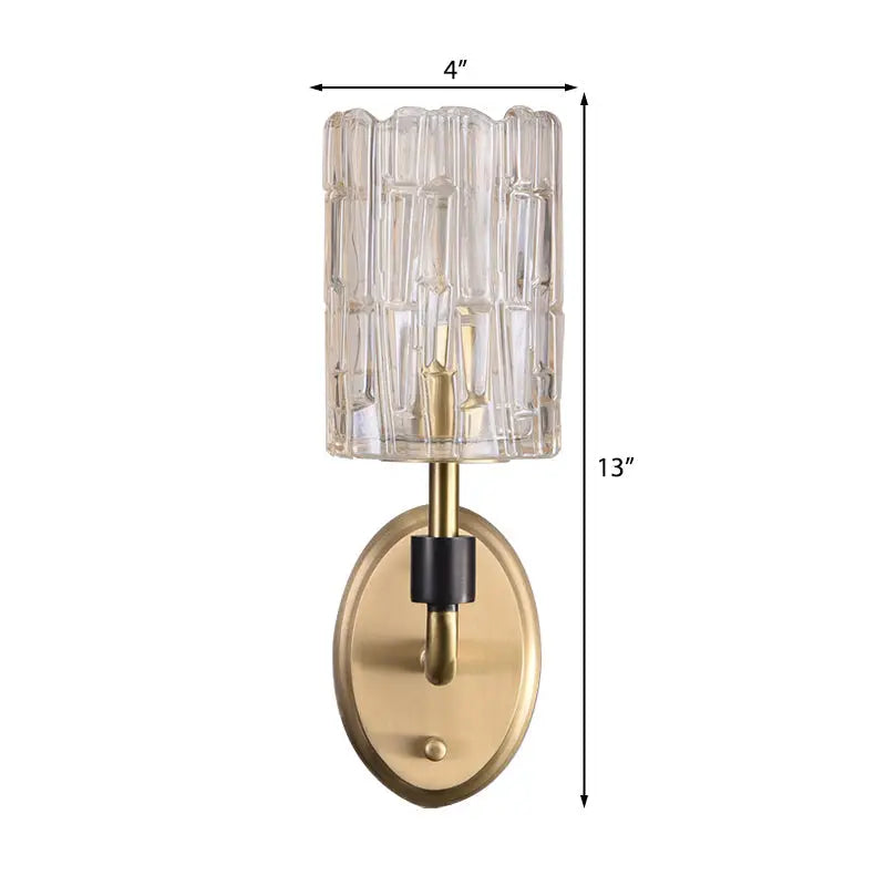 Contemporary brass bedside wall sconce with a clear crystal shade and vertically ribbed glass for bedroom use