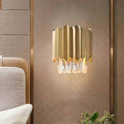 Contemporary wall lamp with classic brass finish featuring vertical metallic slats and crystal droplets for living room