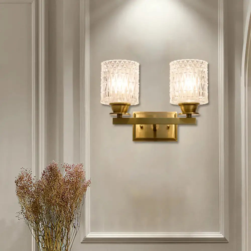 Contemporary brass-finished wall light with direct wired electric power source and frosted lattice glass shades