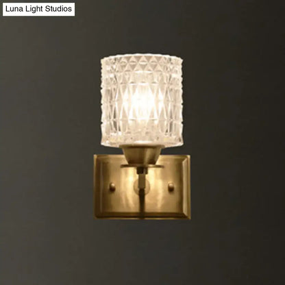 Contemporary brass lattice glass wall light with clear faceted glass lampshade and direct wired electric power source